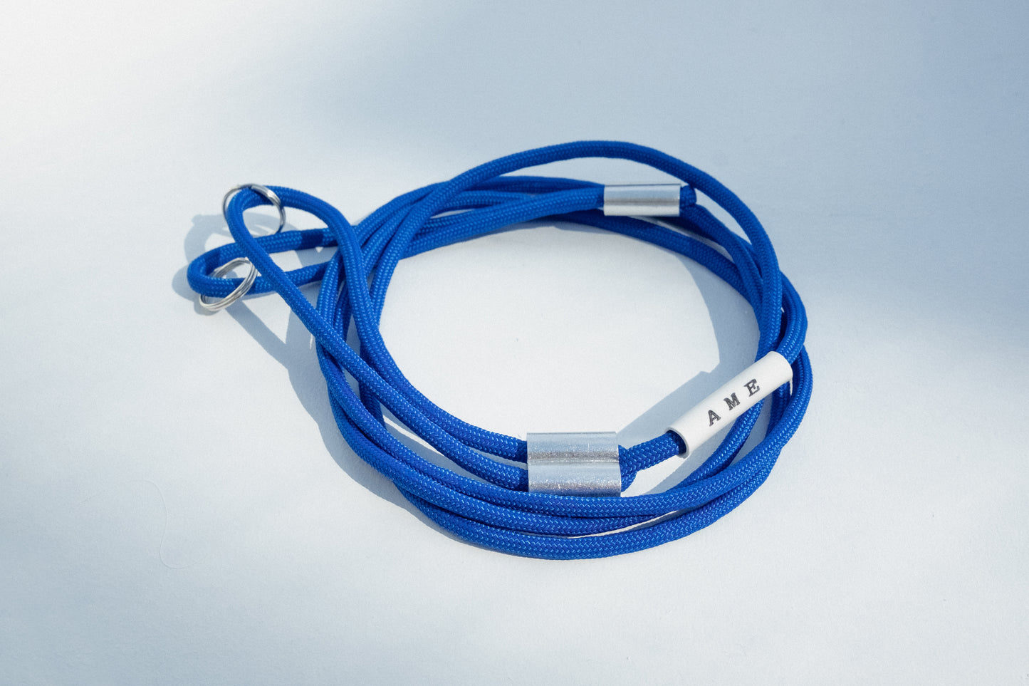 AME x Wolf Camera Strap in der Light Version in der Farbe Dunkel Blau. Du finanziert 1 Monat Schule mit dem Kauf.