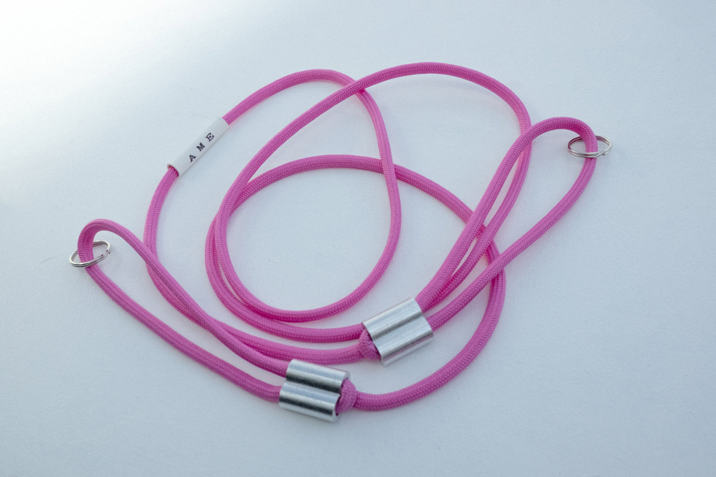 AME x Wolf Camera Strap in der Light Version in der Farbe Pink. Du finanziert 1 Monat Schule mit dem Kauf.