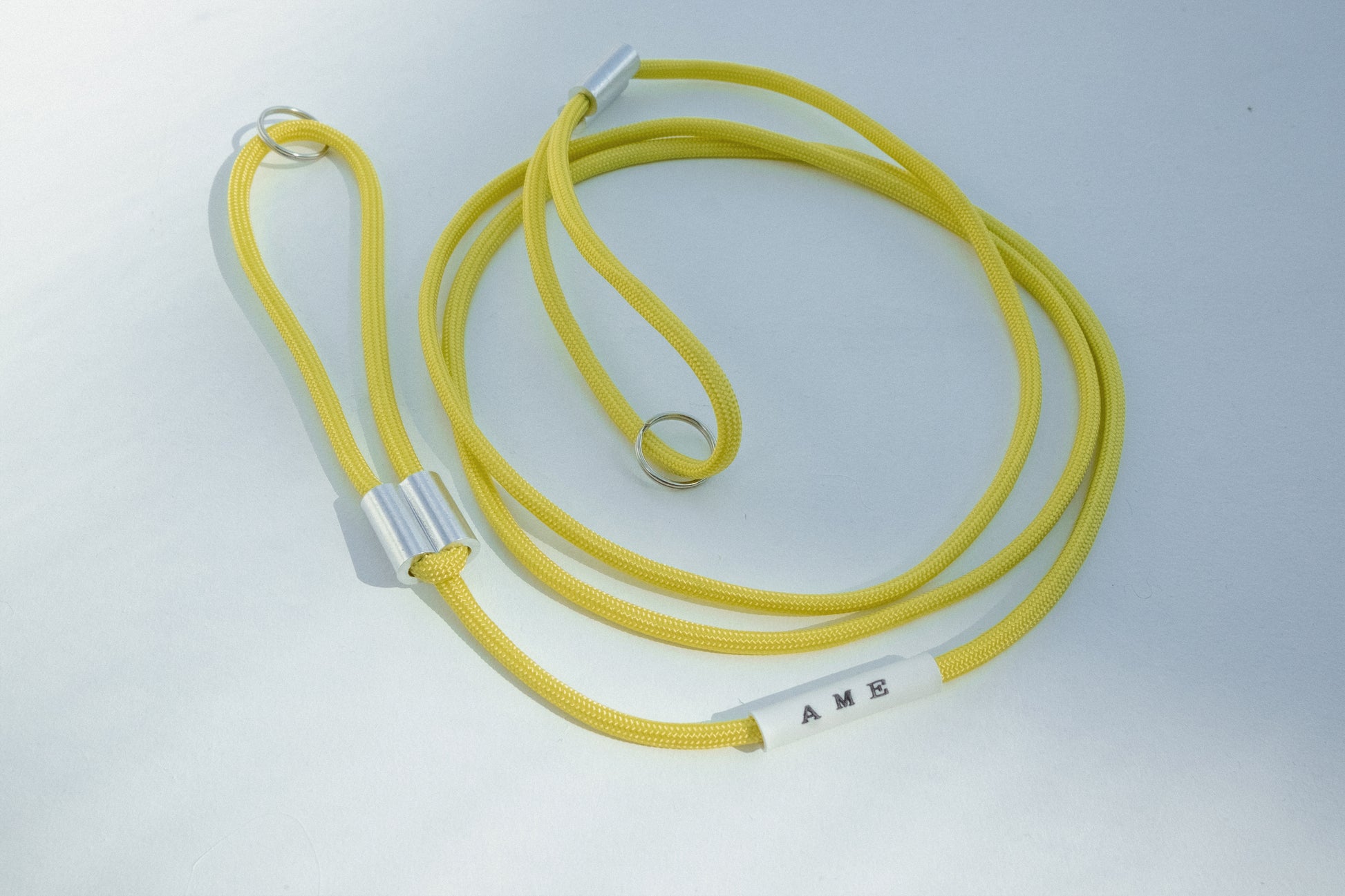 AME x Wolf Camera Strap in der Light Version in der Farbe Gelb. Du finanziert 1 Monat Schule mit dem Kauf.