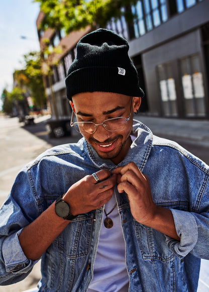 Unsere AME unisex Strickmütze in der Farbe schwarz aus 100% GOTS zertifzierter Merino Schurwolle getragen von Wesley in Barcelona, hergestellt in Deutschland.
