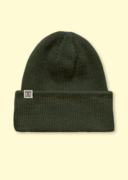 Nachhaltig produziertes Beanie in grober dunkelgruener Wolle.